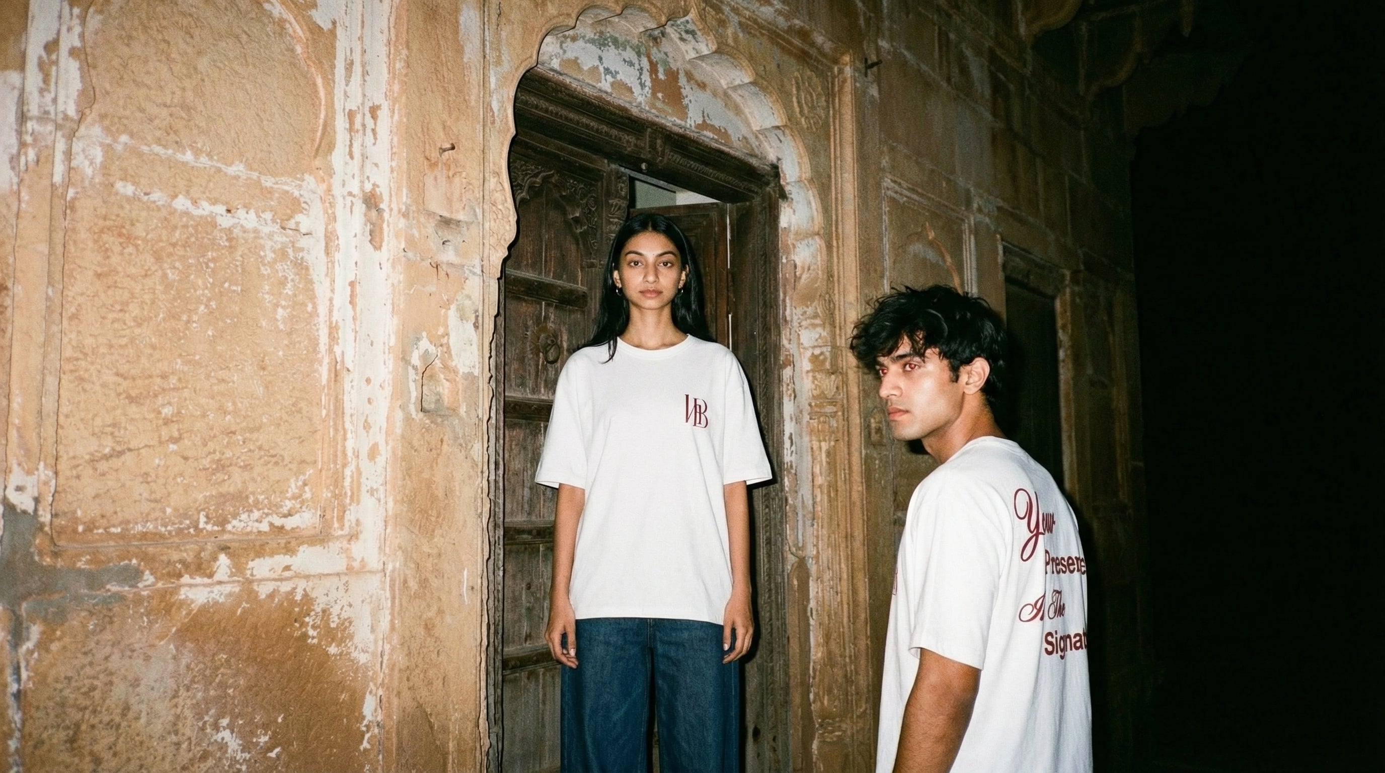 Hallberd Legacy Line — two models wearing oversized 
graphic t-shirts in haveli at night, flash candid 
lifestyle photography India